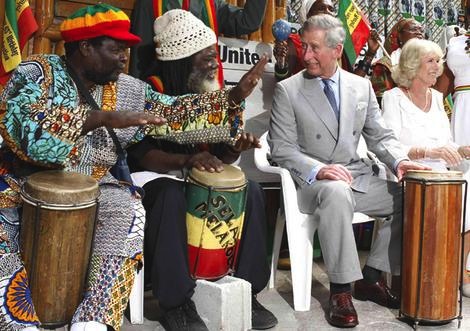 Britain's Prince Charles is shown how to play drums alongside Camilla, Duchess of Cornwall, during their visit to Bob Marley Museum in Kingston